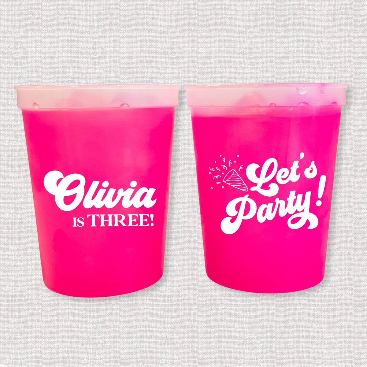 Magenta color changing kids birthday stadium cups with Olivia is Three name and Let's Party design