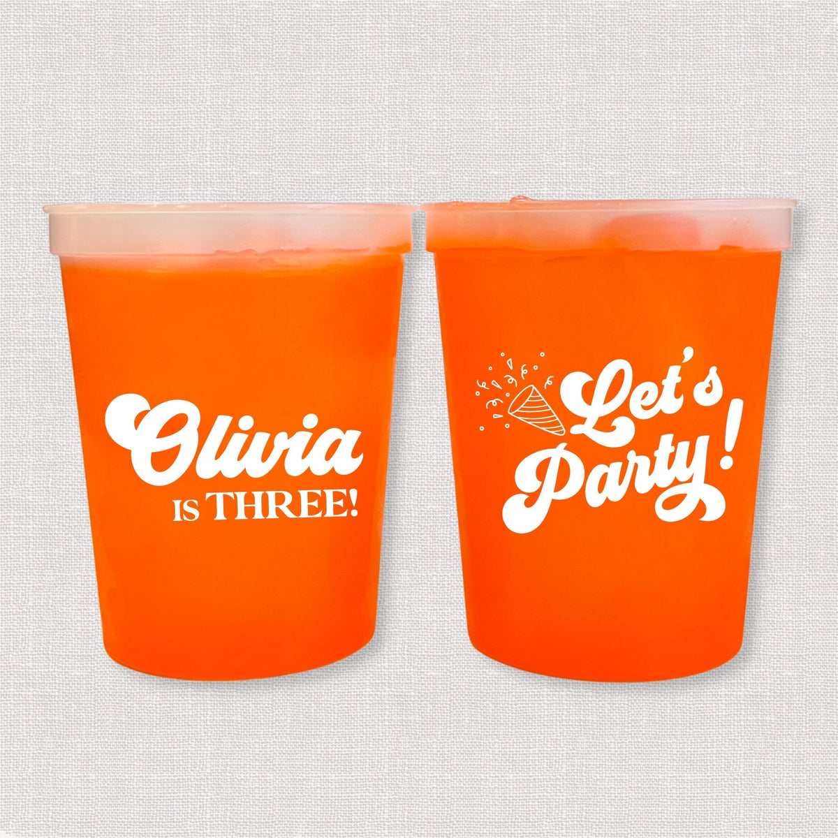 Orange color changing kids birthday stadium cups with Olivia is Three name and Let's Party design