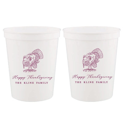 Two white plastic stadium cups, each featuring a festive purple outline turkey graphic, ideal for a Thanksgiving event.