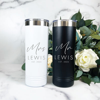 A set of personalized white and black insulated stainless steel tumblers with silver lids, designed as matching wedding or bridal shower drinkware.