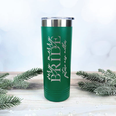 A tall, green insulated metal tumbler with a silver lid, custom-engraved for a bridal celebration with a festive holiday theme.
