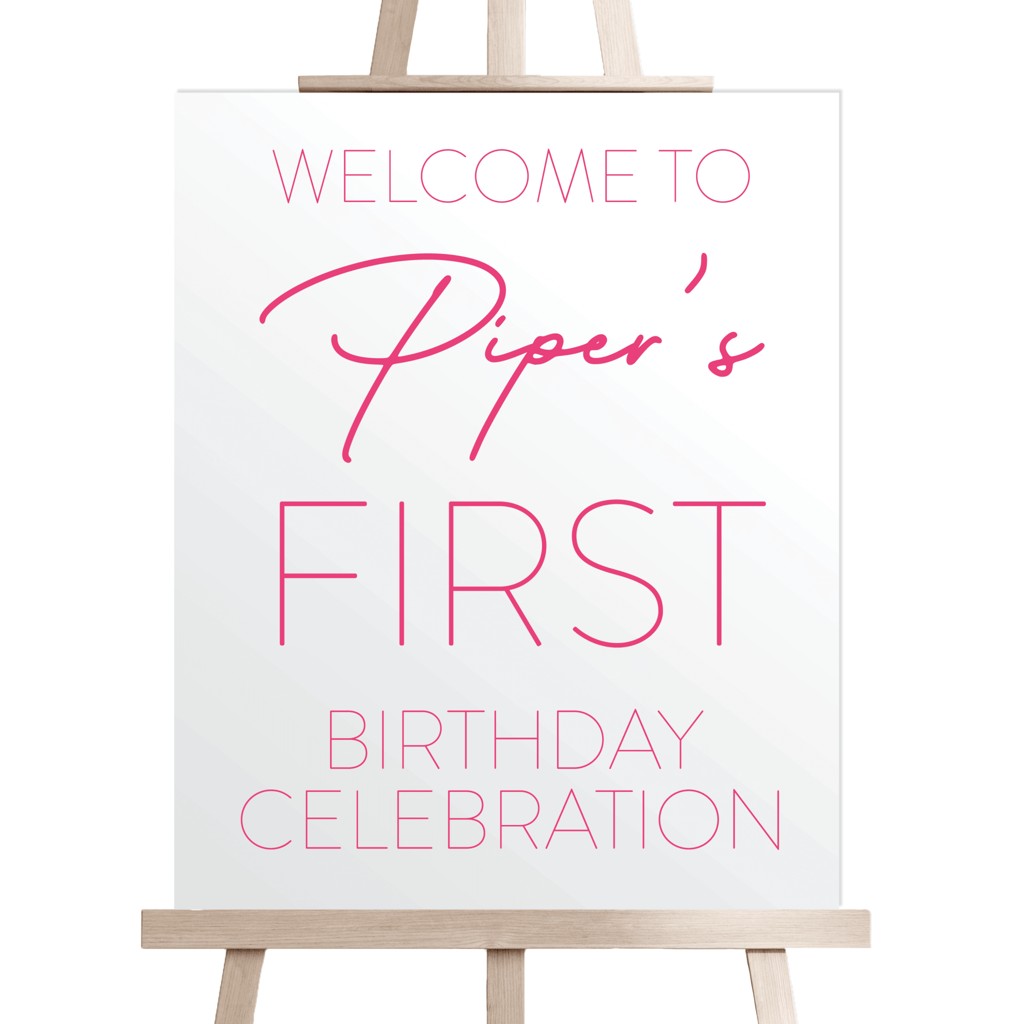 White welcome sign on wooden easel with pink text reading "Welcome to Piper's First Birthday Celebration"