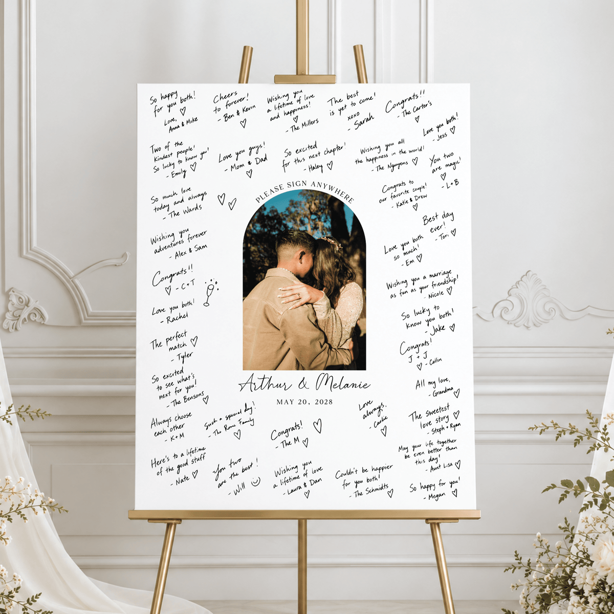 Custom wedding signature board with an arched couple's photo, personalized names and wedding date, surrounded by handwritten well wishes on a white foam board.